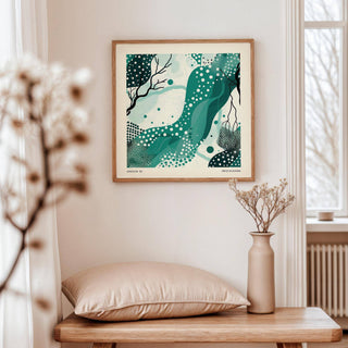 Nature wall art with abstract green shapes and white dots above a beige cushion on a wooden table