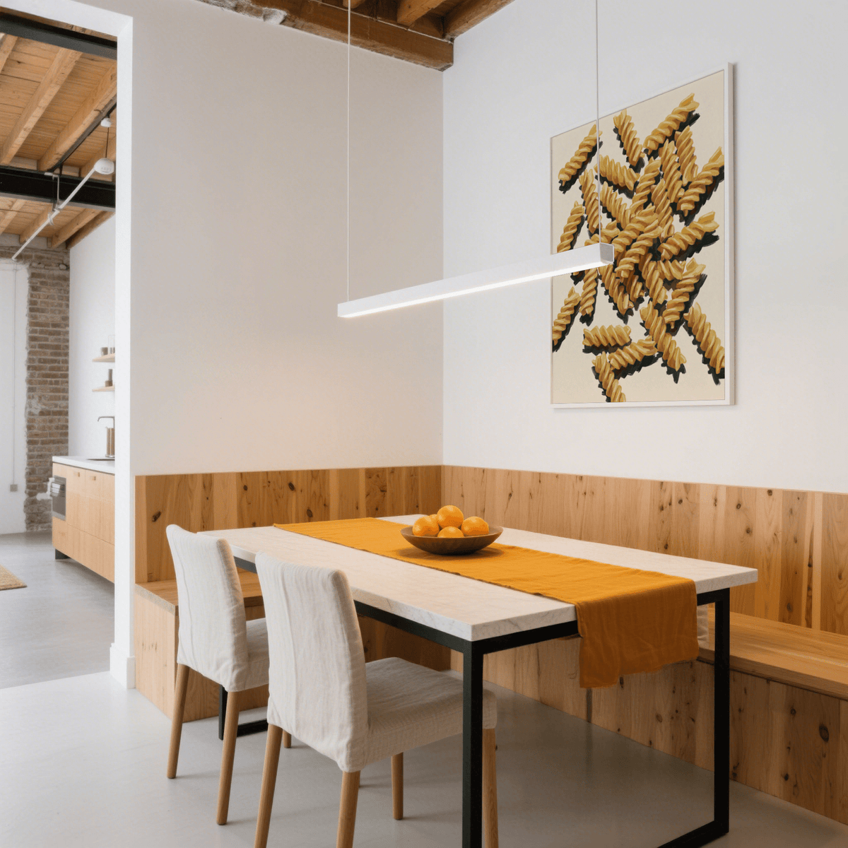 Print of fusilli pasta artwork in yellow and beige above a dining table with an orange runner
