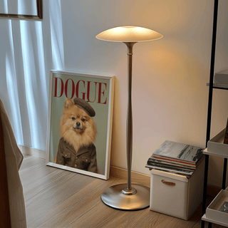 Pomeranian wall art leaning against a wall next to a floor lamp with soft warm light