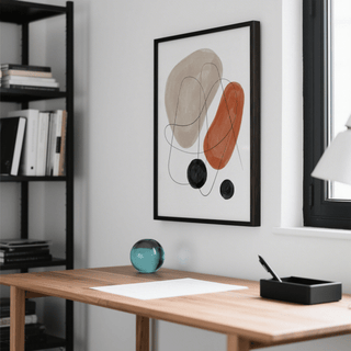 Abstract Shapes Art Print framed with abstract shapes in muted earth tones above a wooden desk with glass paperweight