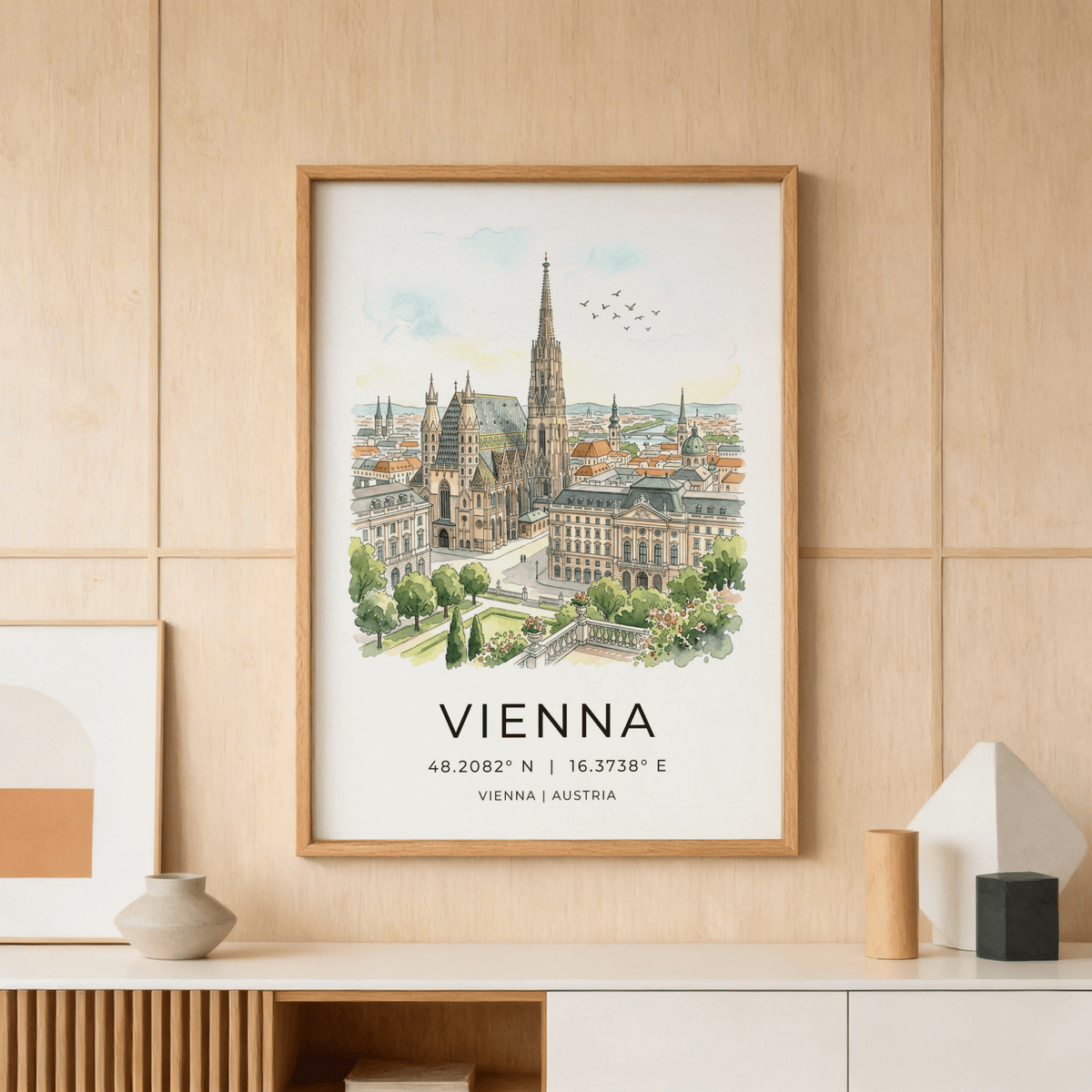 Framed Vienna Cityscape Art Print showing St Stephens Cathedral and surrounding buildings in watercolour style on a shelf with vases