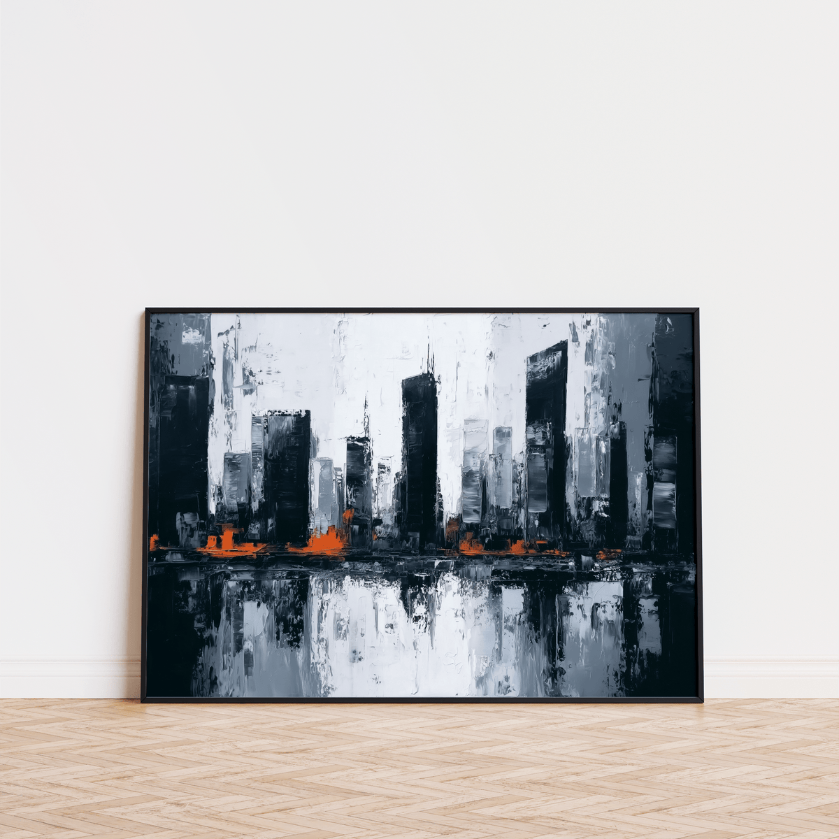 Abstract city wall art leaning on floor with black frame and orange accents on a white wall