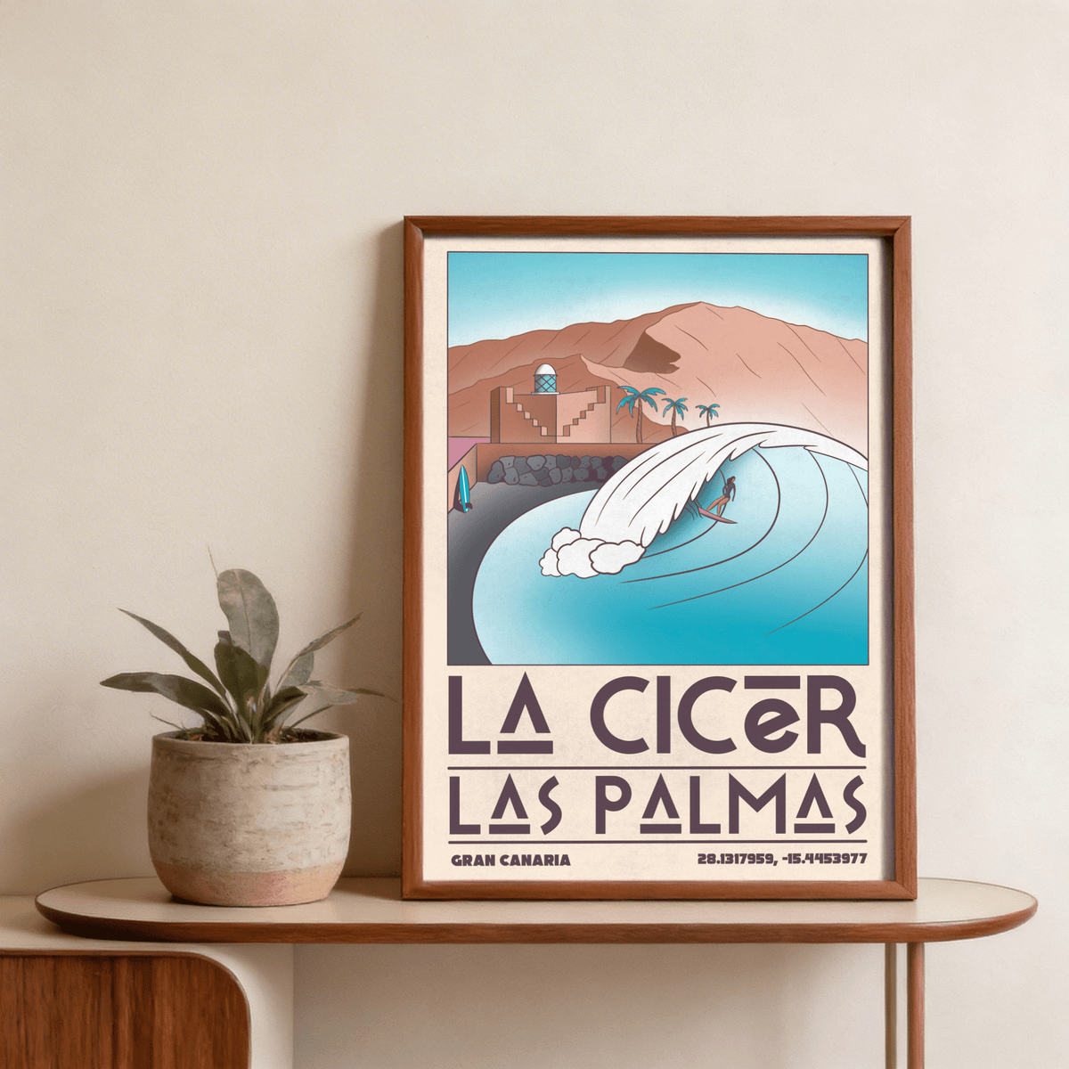 Las Palmas wall art showing a surfer on a wave in pastel colours with a wooden frame and a plant nearby