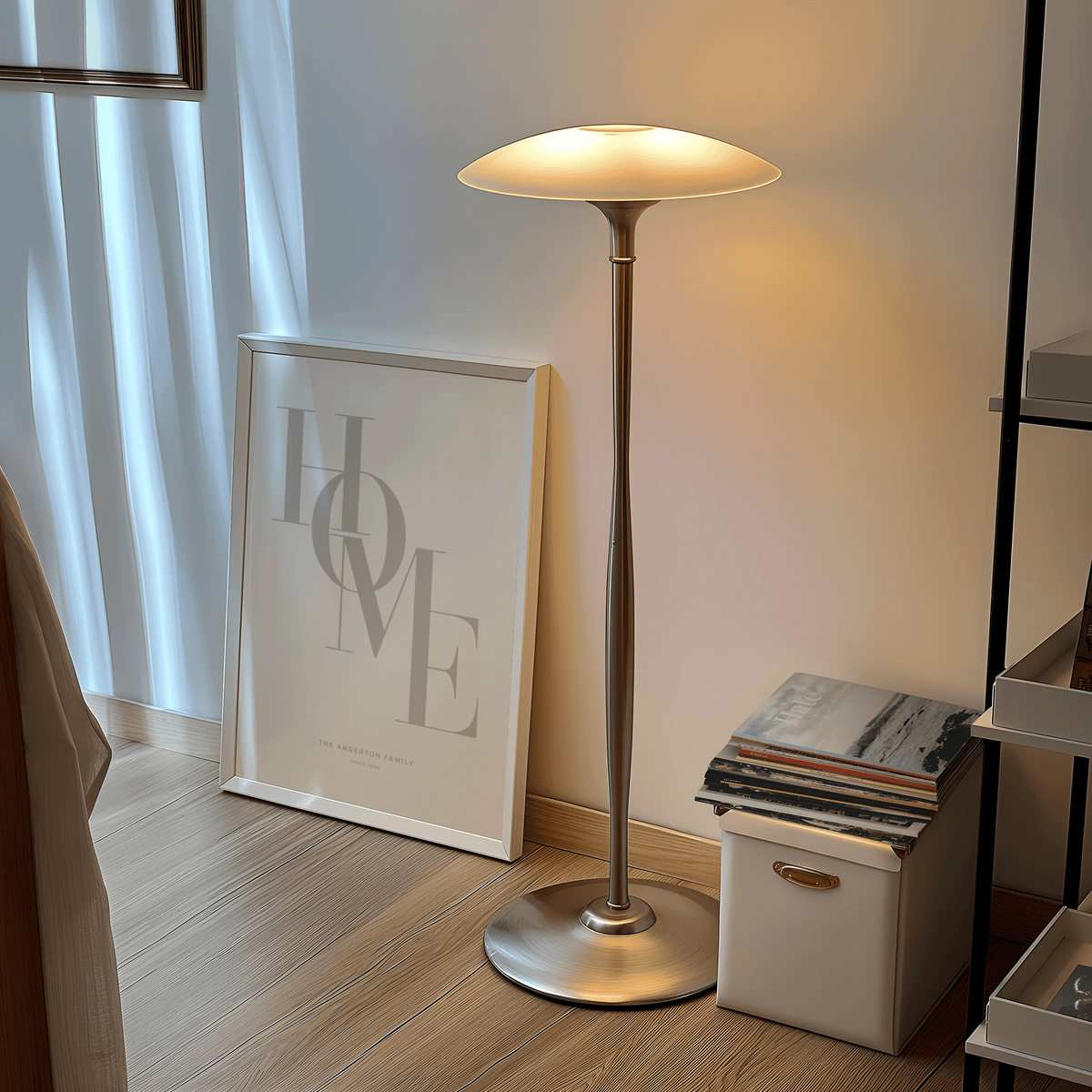 Print leaning on a floor with HOME typography in beige next to a tall lamp and stack of books