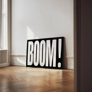 Modern Typography Wall Art with bold white boom typography on black leaning on a wooden floor