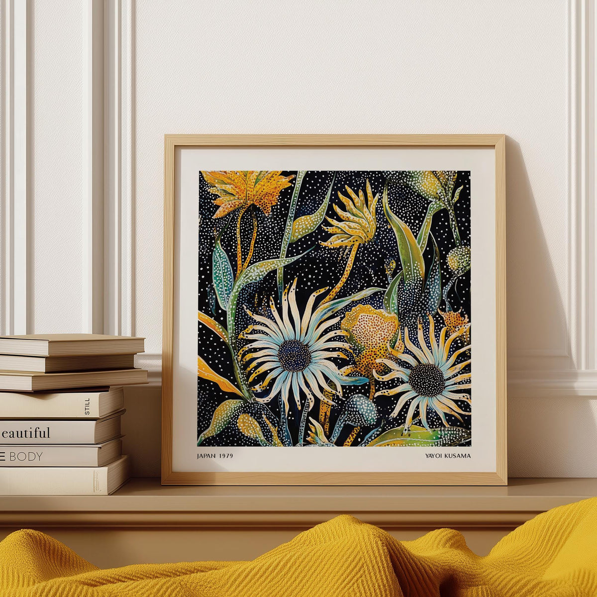 Abstract art floral print leaning on a shelf with books and a yellow throw nearby
