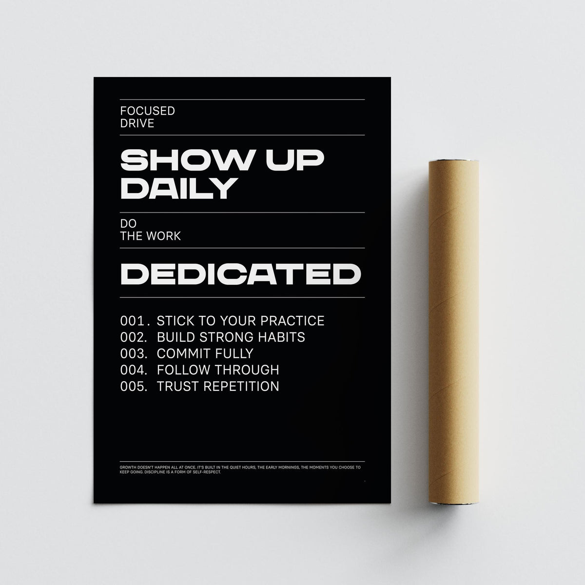 Show Up Daily II wall art with black background and white minimalist typography next to a rolled packaging tube