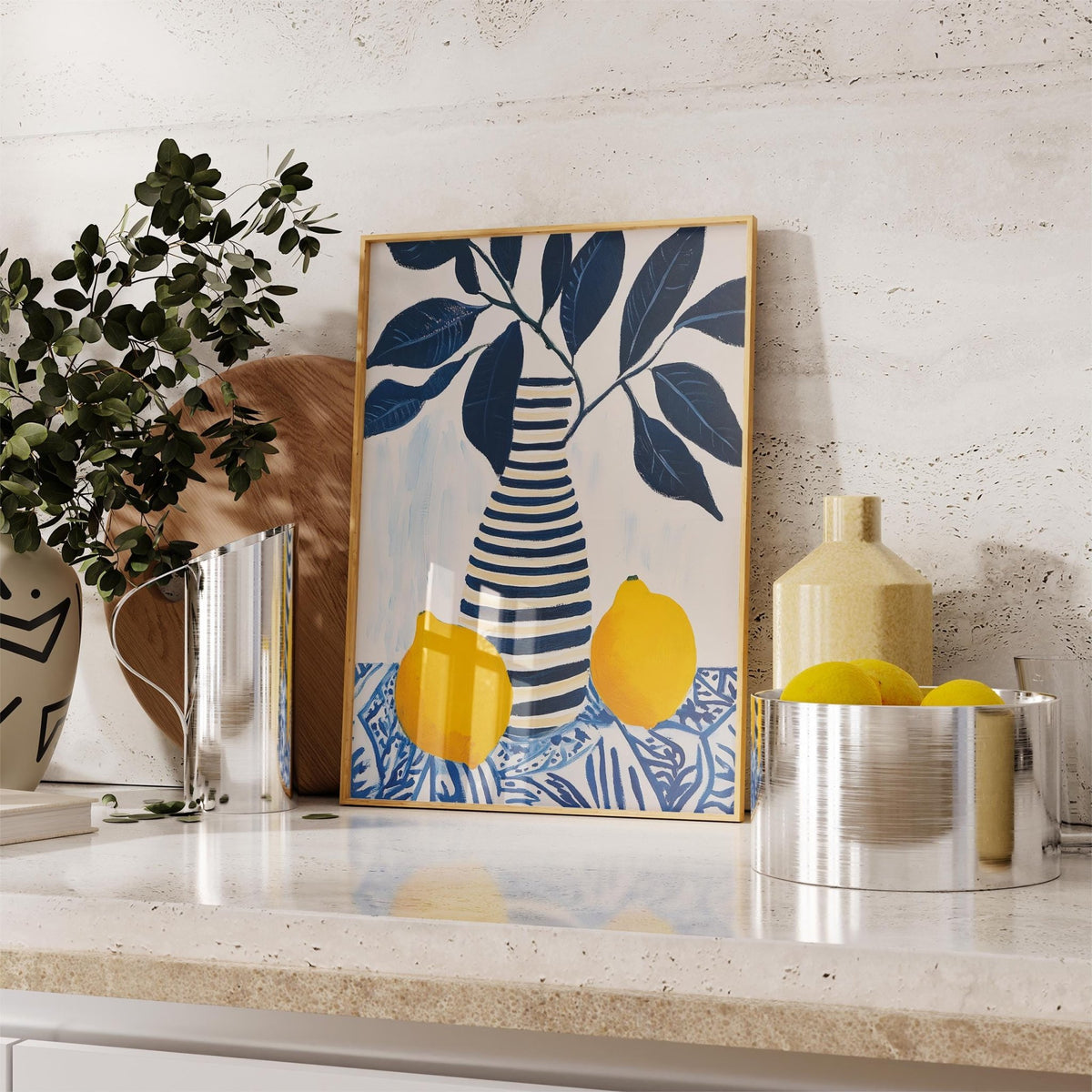 Print leaning on a kitchen counter of Lemon art print with navy striped vase and yellow lemons and leaves