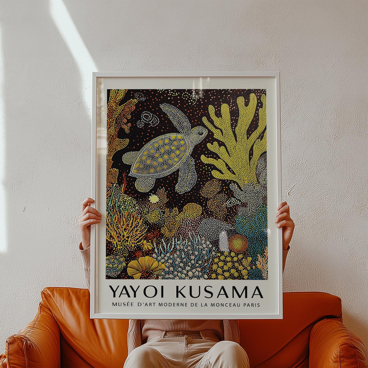 Framed Sea Turtle Wall Art held by hands with a brown leather sofa in the background