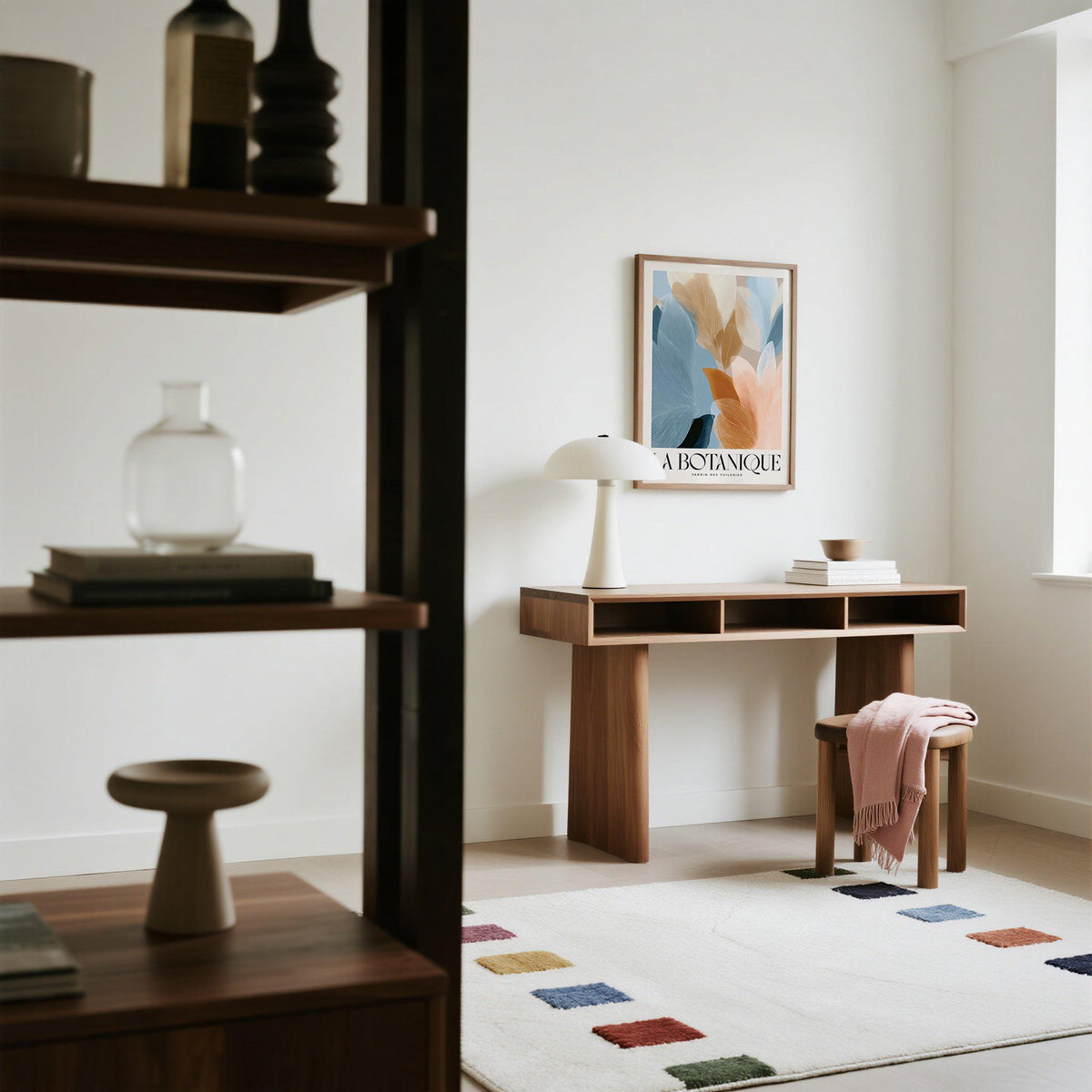 Print on a wall in a minimalist room with abstract botanical leaves in blue and pink above a wooden desk