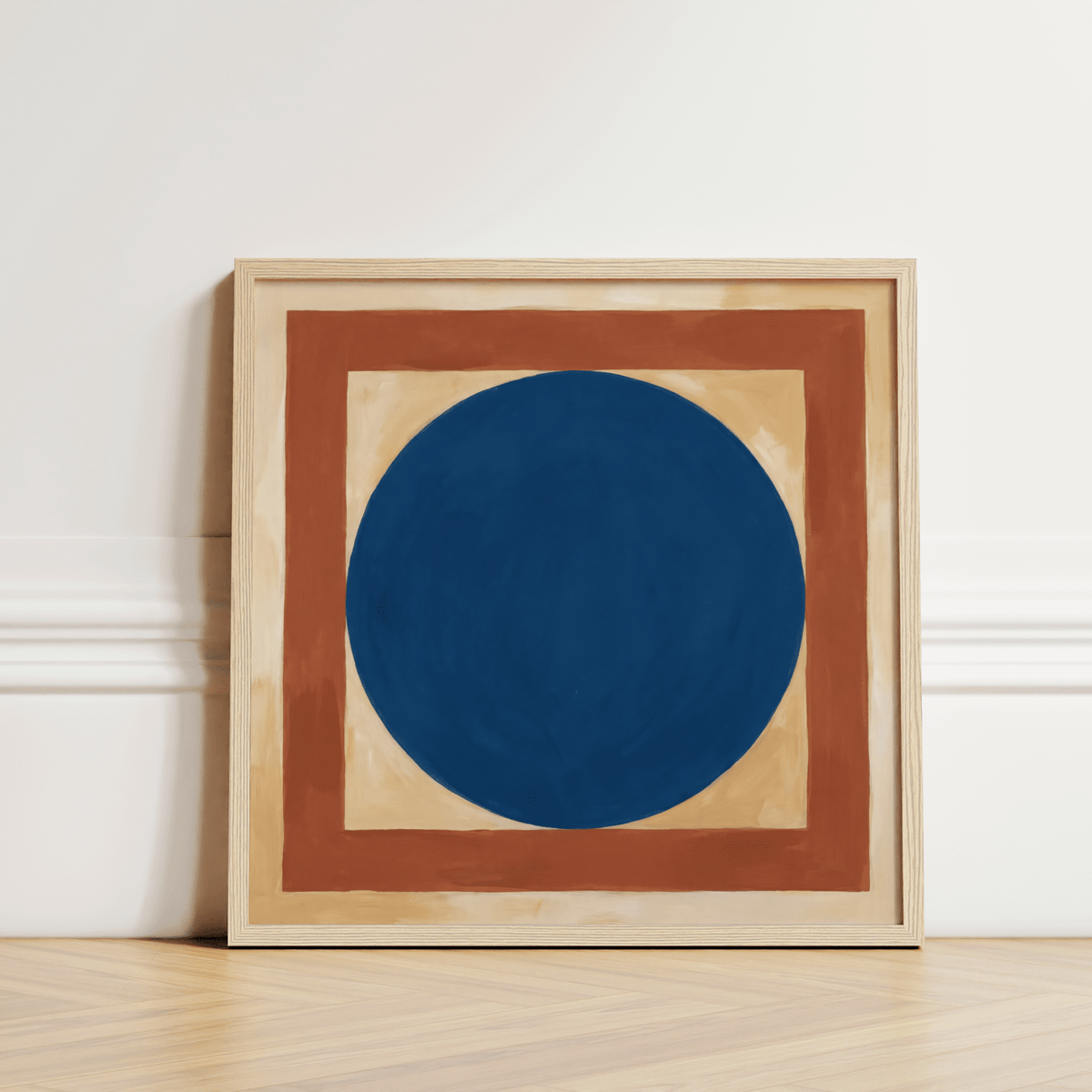Minimalist Circle Art print leaning on parquet floor showing a blue circle with two squares in earthy tones