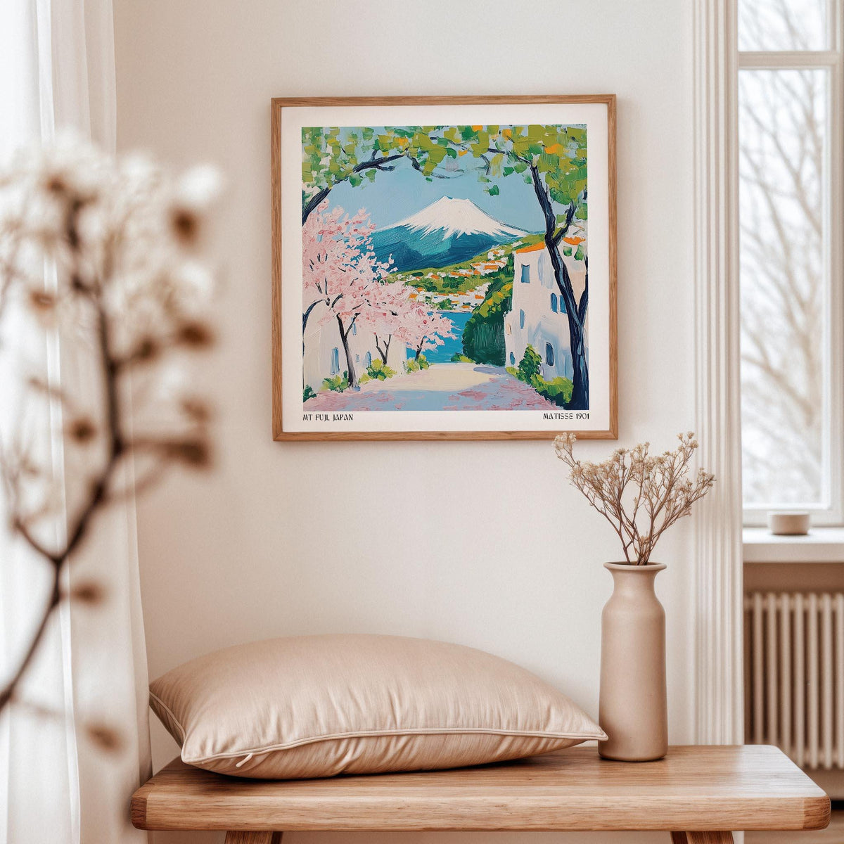 Japan Poster framed print with Mount Fuji and pink cherry blossoms above a beige cushion and next to a vase
