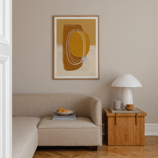 Minimalist Organic wall art with abstract shapes in brown and ochre above a beige sofa and wooden side table