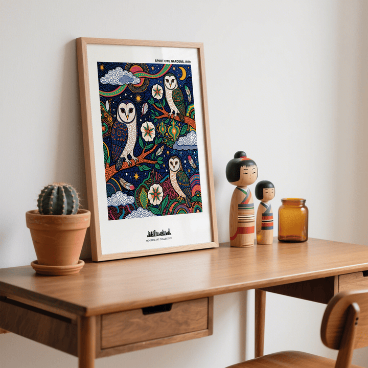 Print leaning on a desk of a barn owl trio folk-art illustration with dark blue and orange hues