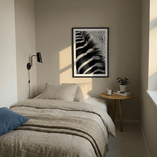 Zebra Stripe Art Print on a bedroom wall above bed with bedside table and plant