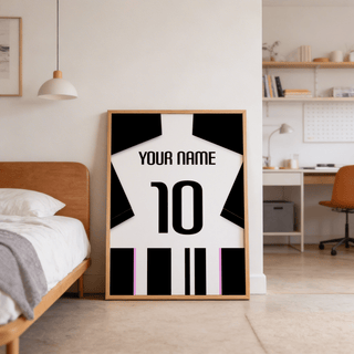 Print leaning on floor of football shirt poster in black and white stripes with pink accents by a bed