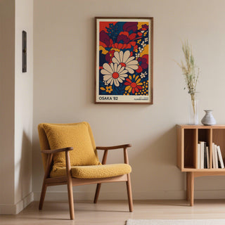 Retro wall art print of daisy flowers in bold colours above a mustard yellow armchair