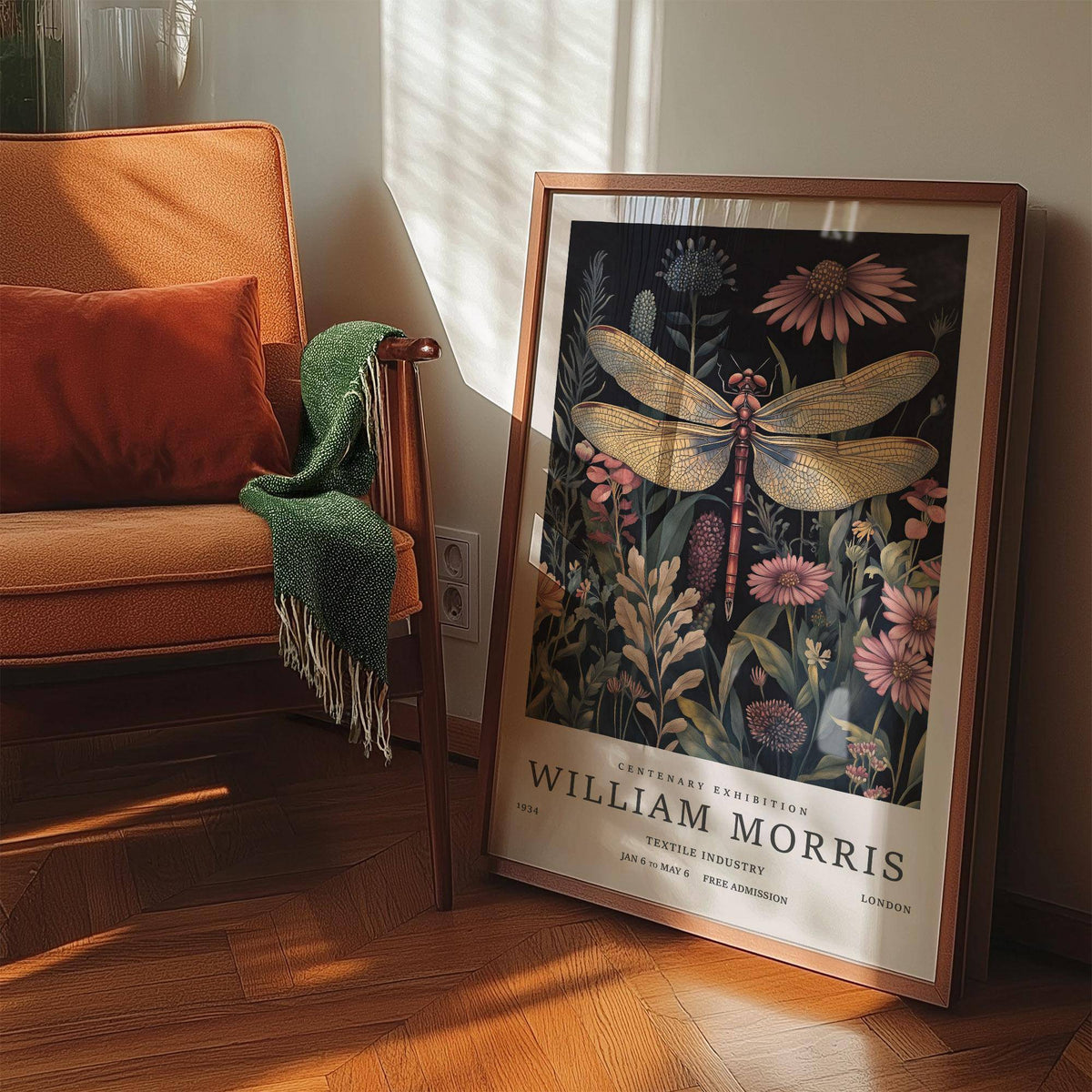 Print leaning on floor of a dragonfly art print with pink flowers and timber armchair nearby