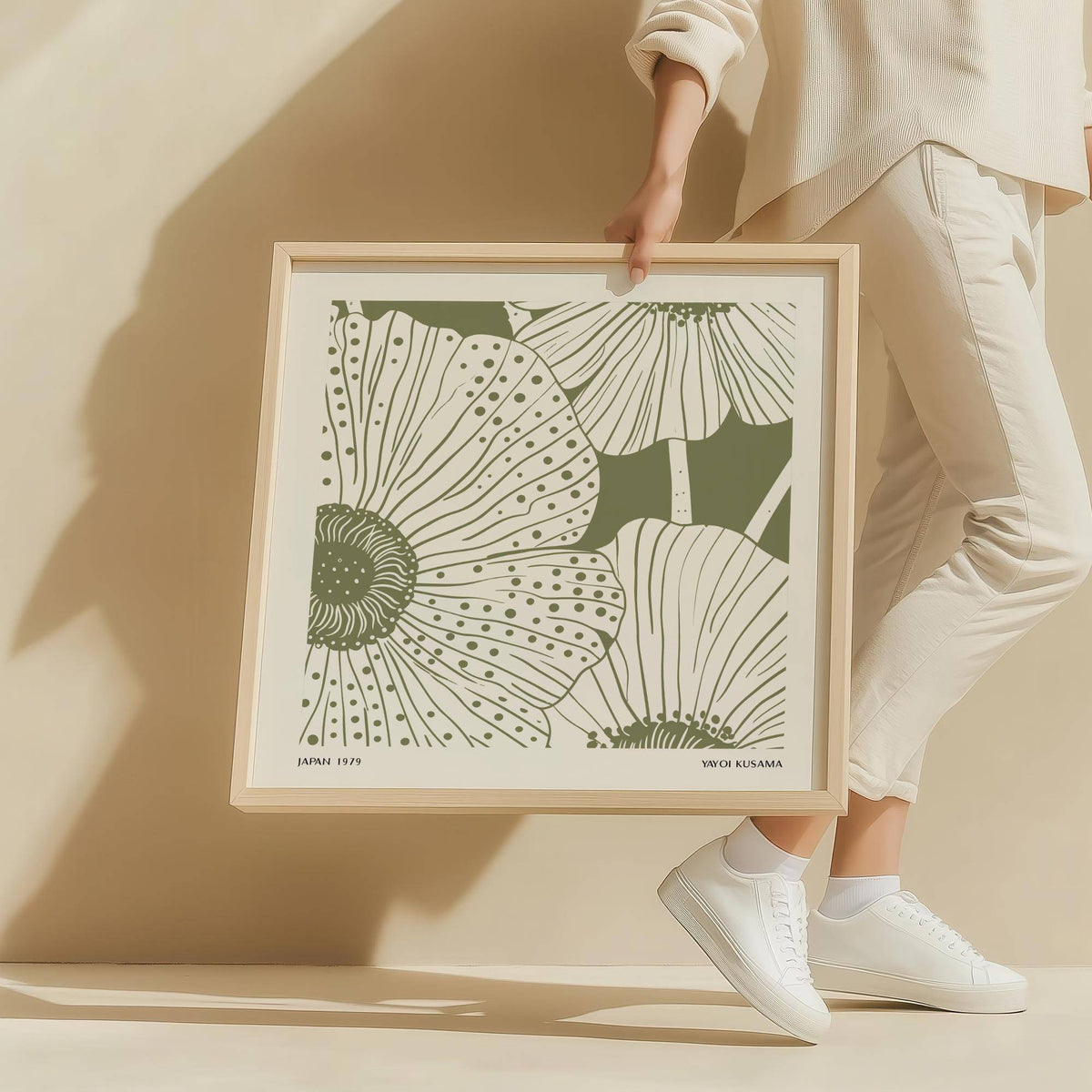 Framed Sage Green Abstract Wall Art with minimalist stylized poppy flowers held by a person