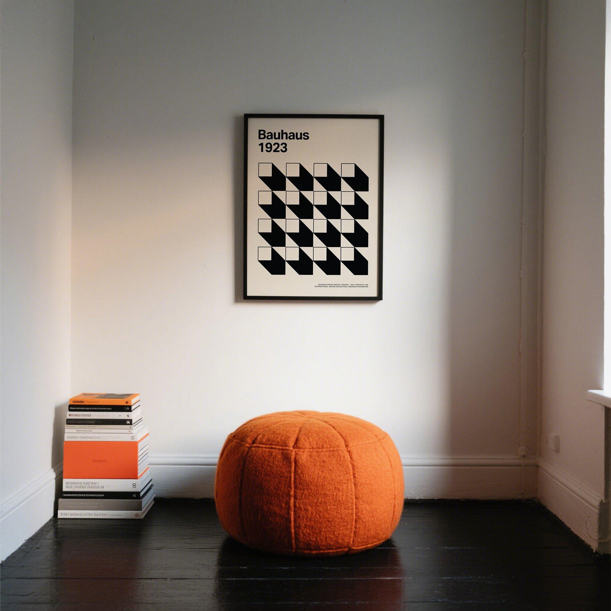 Office Space Poster black and white geometric shapes in a black frame above an orange pouffe in a minimal room