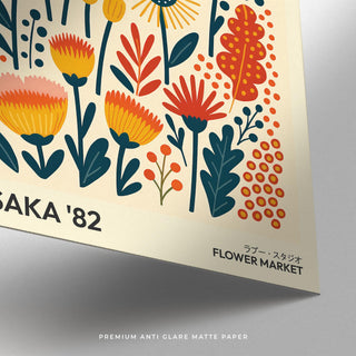 Close-up of wall art flowers with orange and yellow stylised blooms on cream matte paper