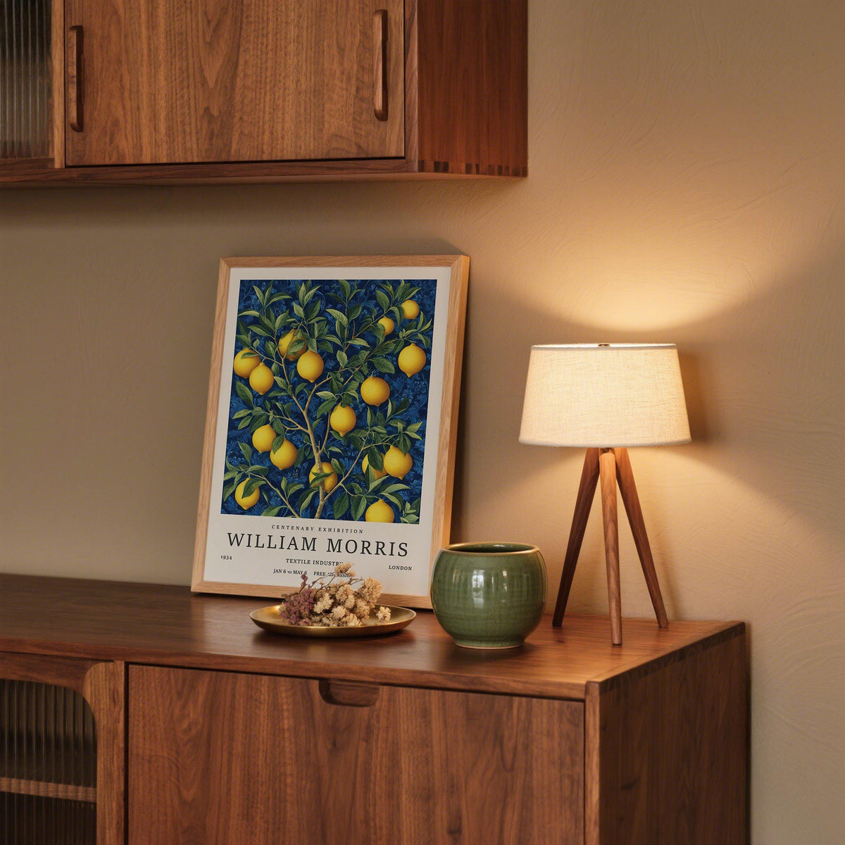 Print leaning on a shelf of lemon wall art with yellow fruit and green leaves near a lamp and green pot