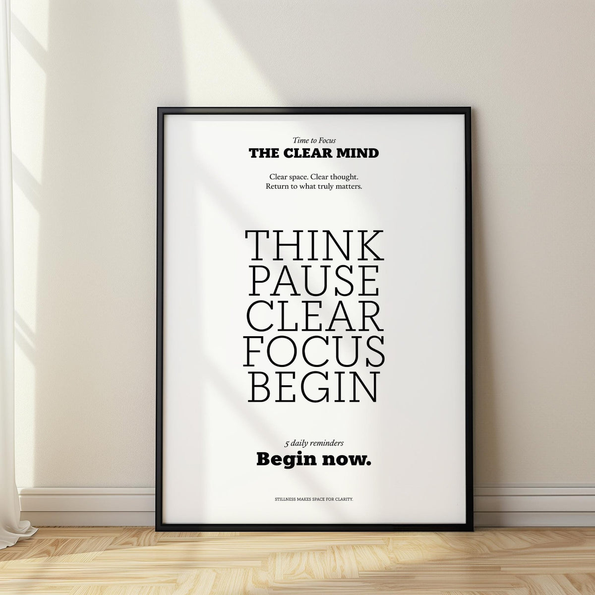 Motivational art for the office with black text on white leaning on the floor near a curtain