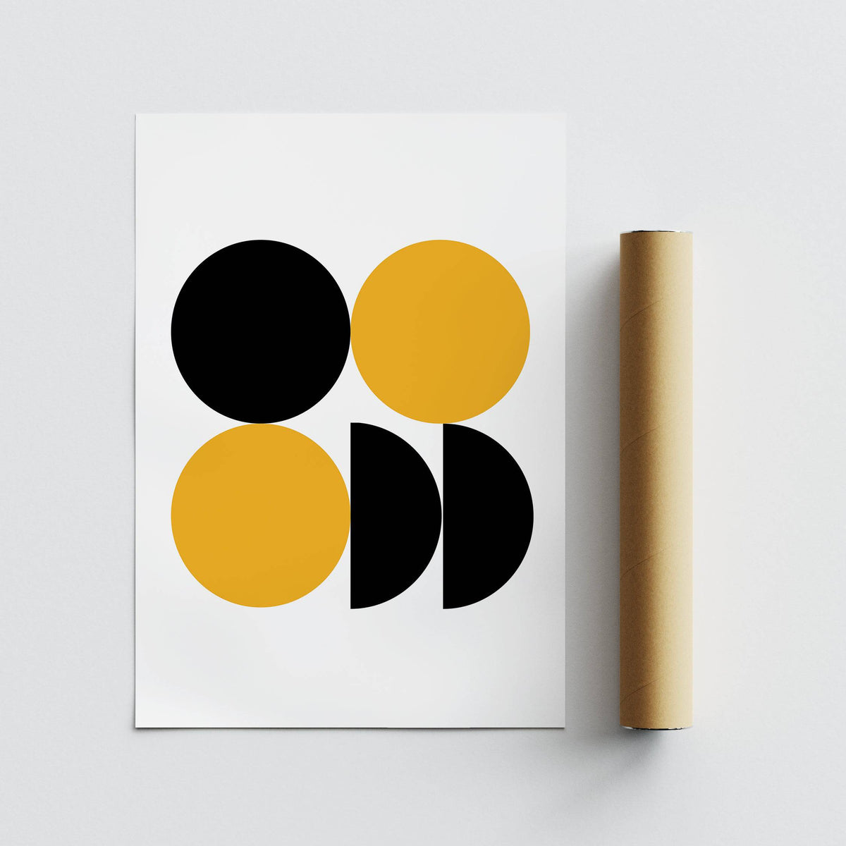 Geometric posters lying next to a packaging tube with black and yellow minimalist shapes