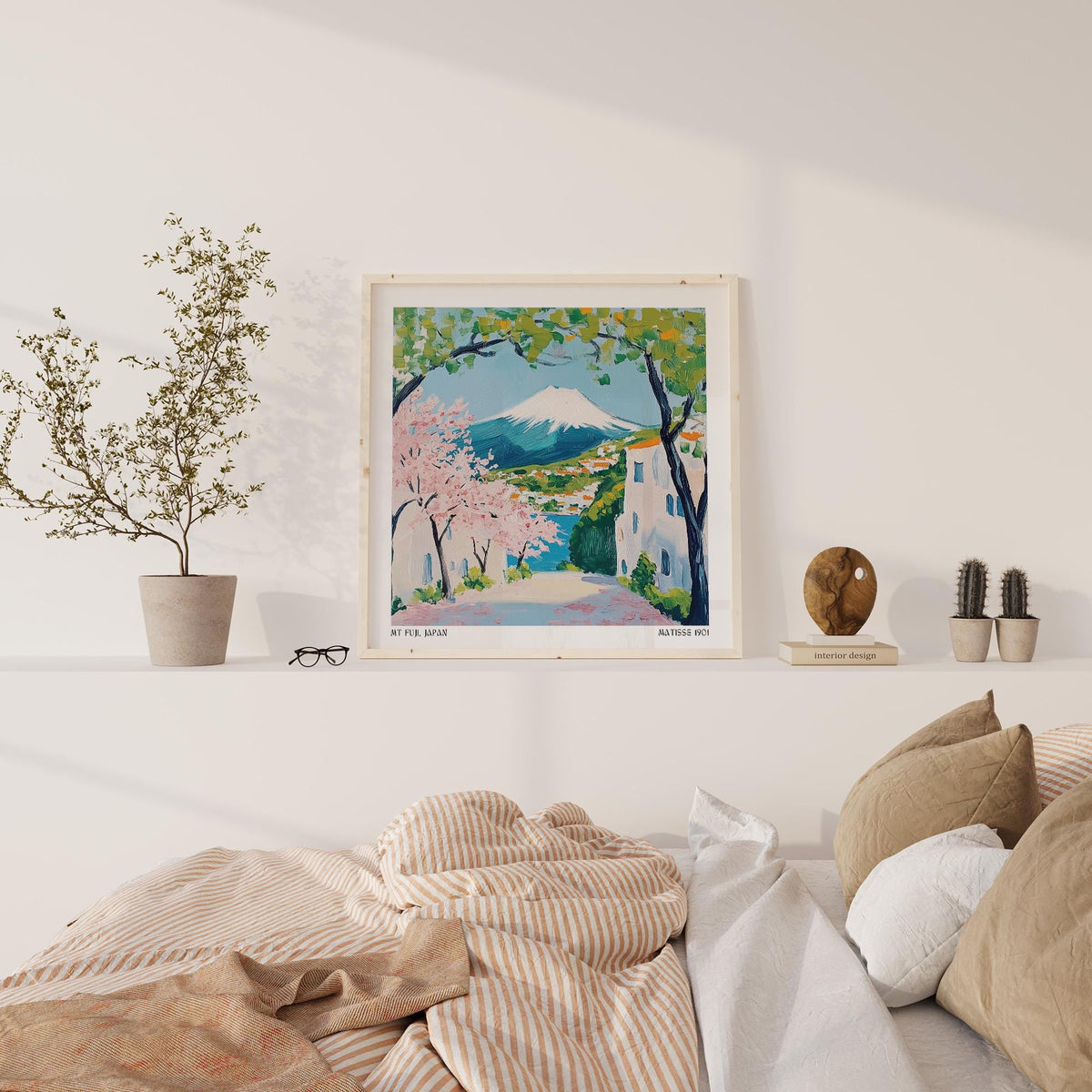 Japan poster print of Mount Fuji with pink cherry blossoms on a white shelf above a bed