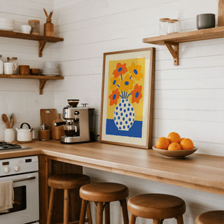 Vase and Flowers Poster print leaning on a kitchen counter with three wooden stools and a bowl of oranges