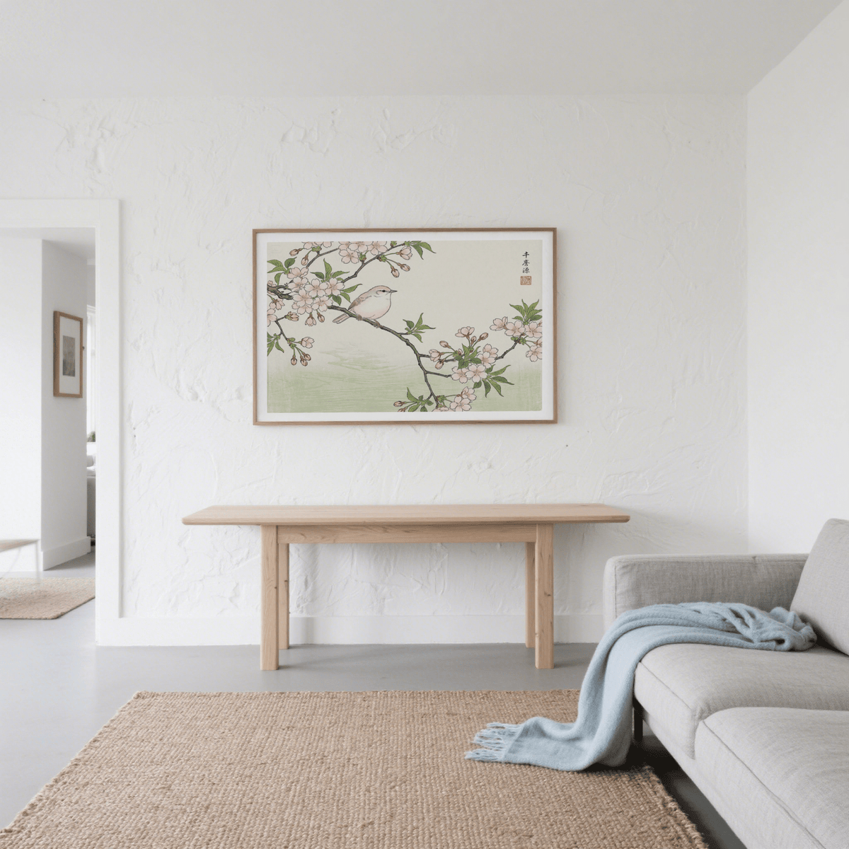 Framed Bird Cherry Blossom Art Print in muted green and pink above a wooden table in a living room