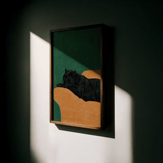 Framed Big Cat Art Print of a black panther lying on an orange couch with a green background lit by sunlight