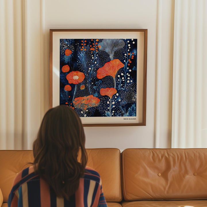 Abstract Flower Art framed print of coral dots pattern in orange and blue above a tan sofa