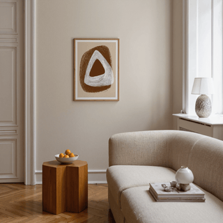 Boho Geometric Art Print hanging above a wooden side table with a bowl of oranges in a living room