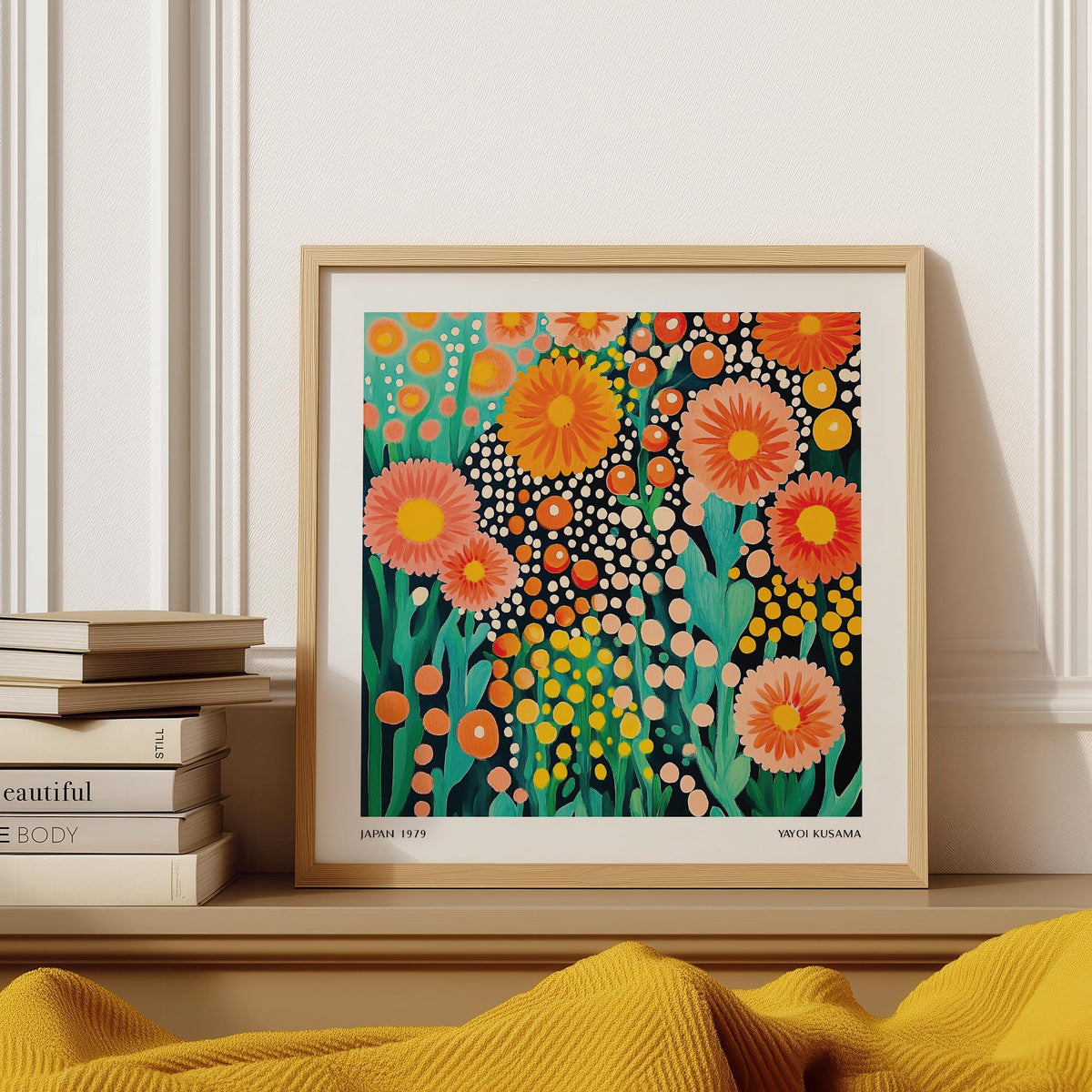 Framed Colorful Flower Art with bright orange and pink blooms resting on a wooden shelf with books nearby