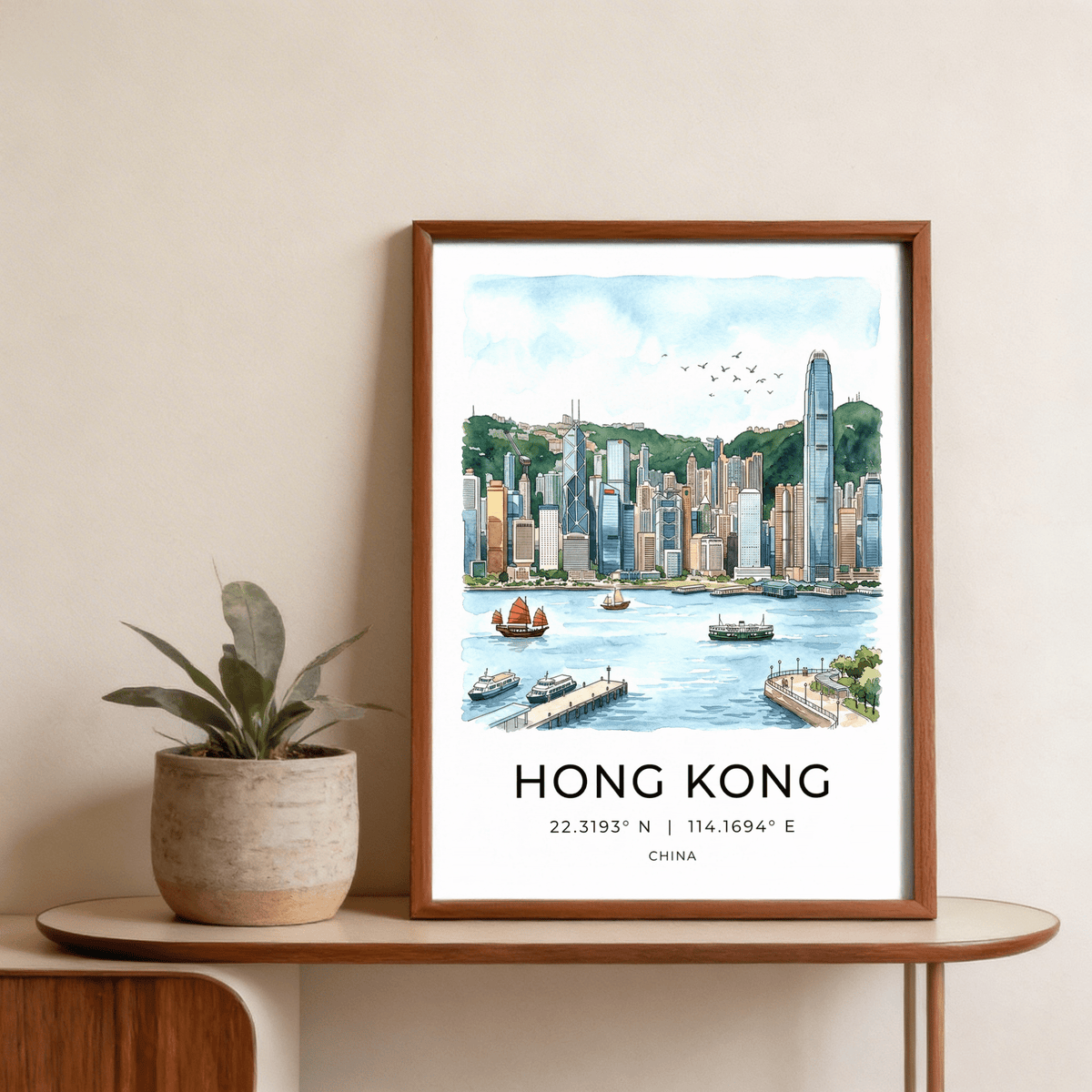 Hong Kong Skyline Art Print in a wooden frame on a table with a potted plant