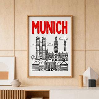 Munich City Poster framed print of minimalist city skyline with red lettering on a wood-paneled wall above a shelf with ceramics
