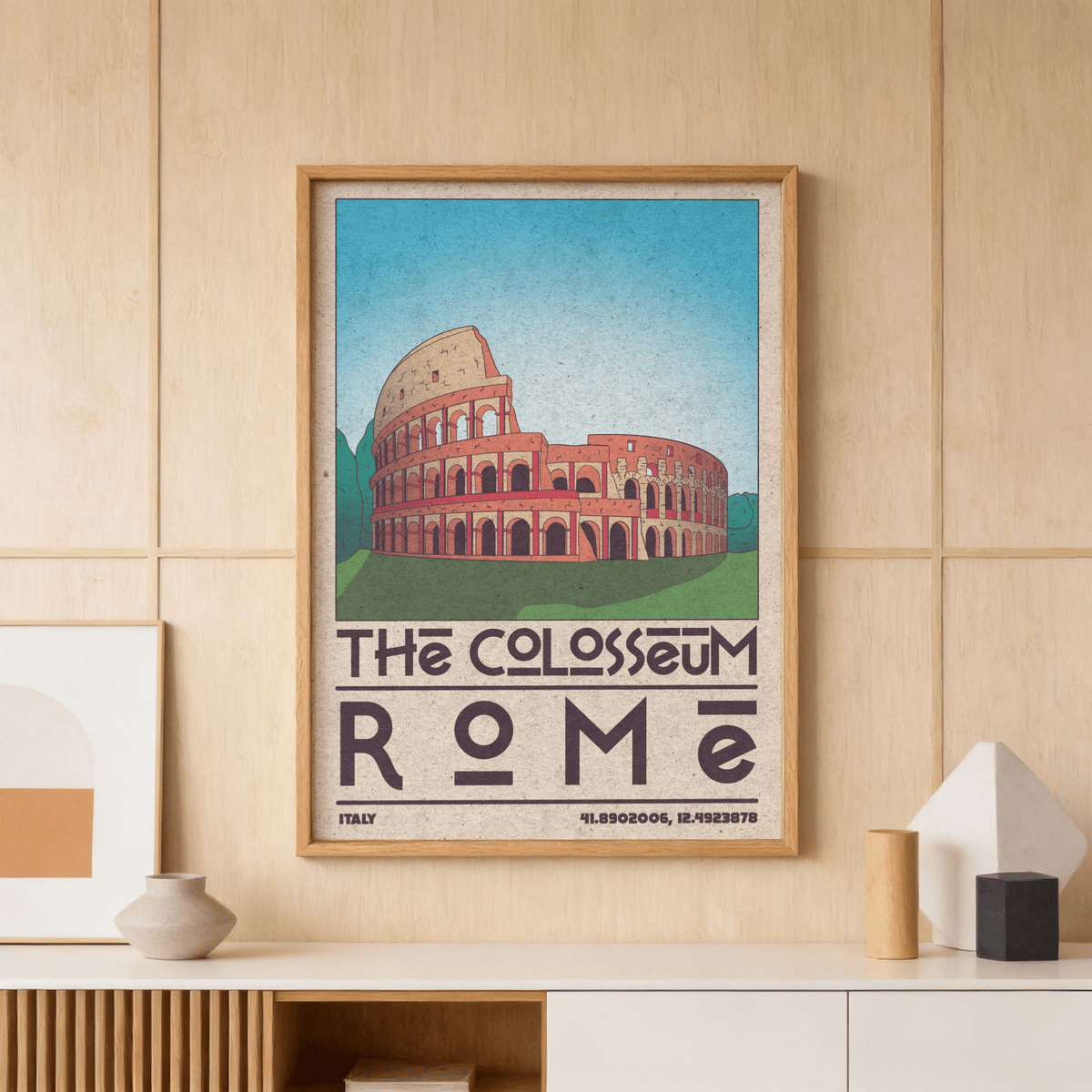 Framed Colosseum art print in soft colours with a ceramic vase on a wooden shelf