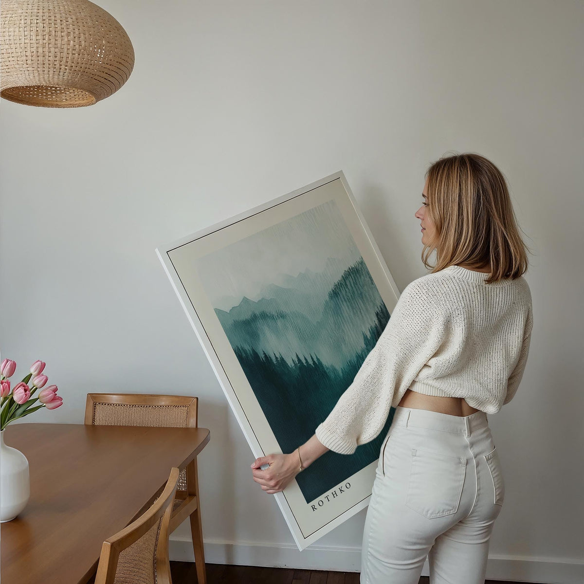 Mountain wall art held by a woman showing misty green and blue mountain layers in watercolour style
