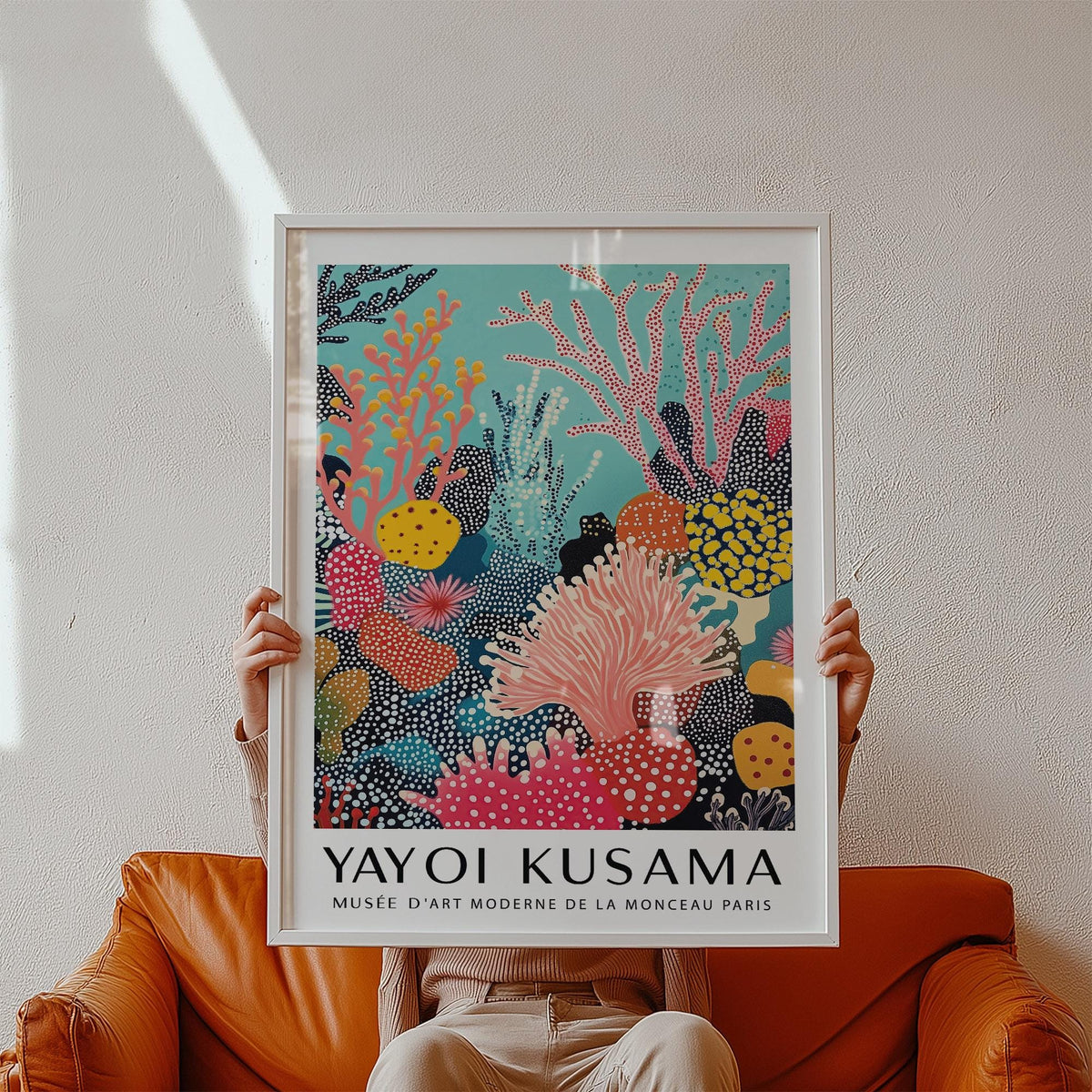 Framed Bright Wall Art showing coral reef in bright colours held above a brown leather sofa