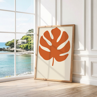 Single split leaf on warm cream leaning by a bright window with a sea view