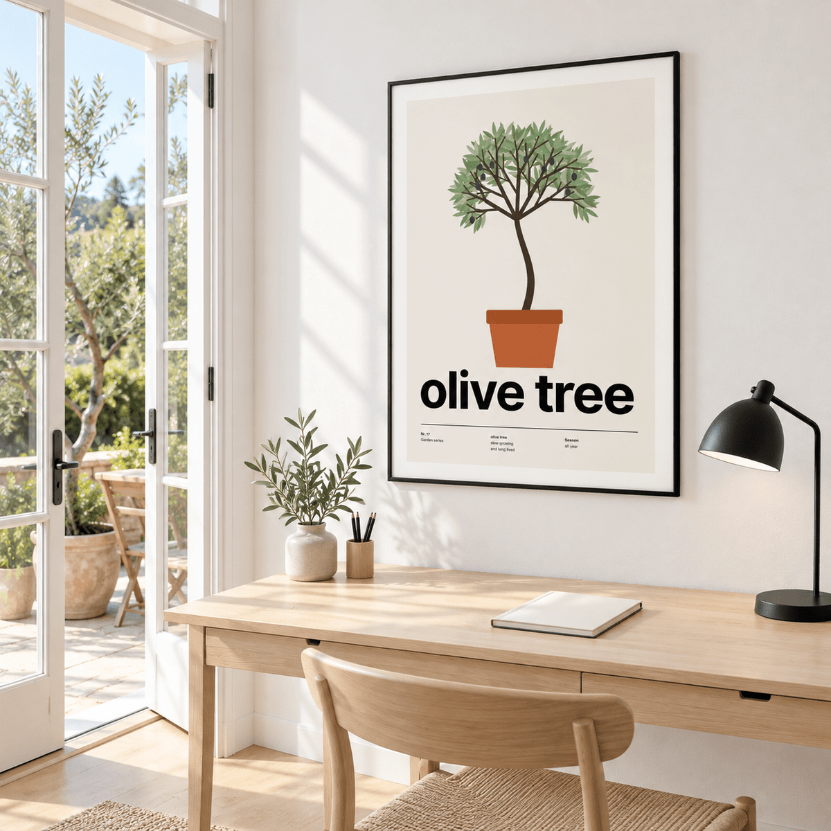 Olive tree in a terracotta pot above a desk beside open garden doors