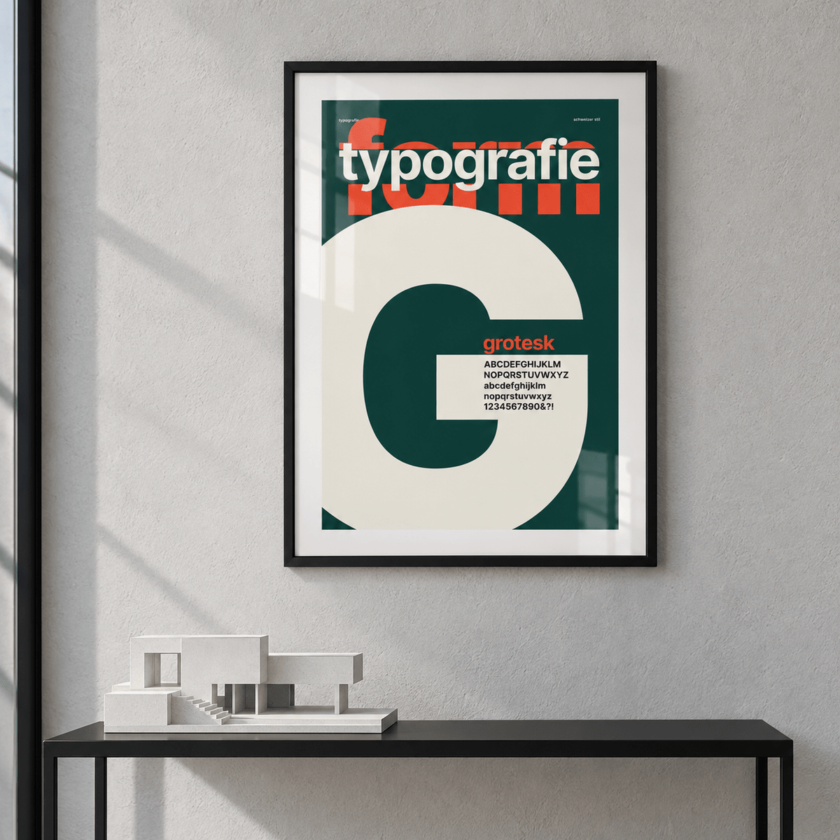Cream letter G on forest green print above a console table in a hallway
