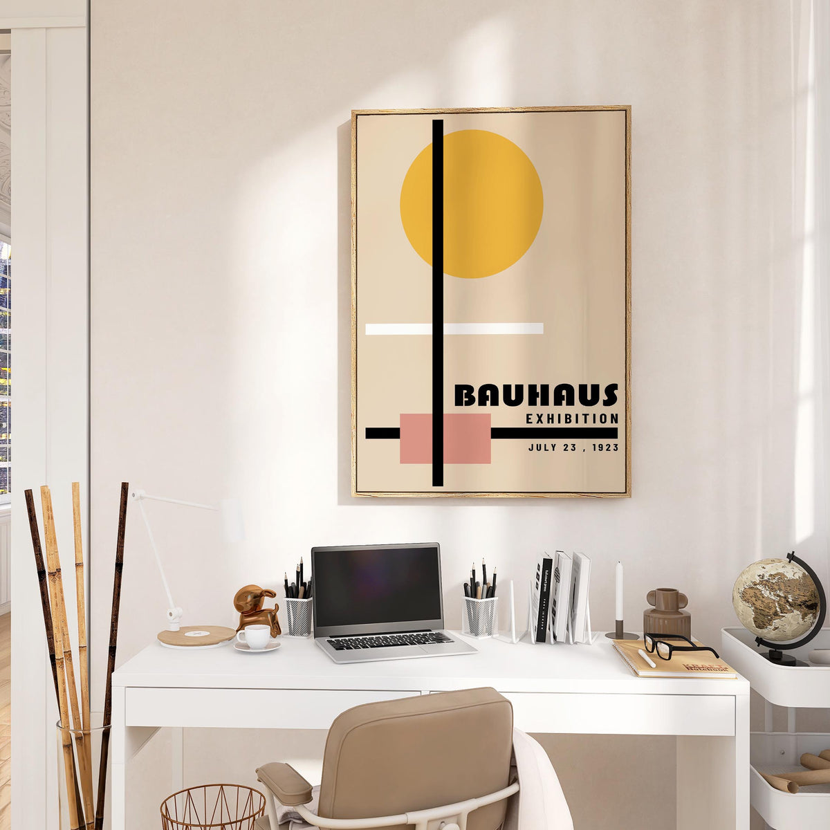 Office Prints in a sunny room with geometric shapes in muted yellow, pink, black and white above a white desk