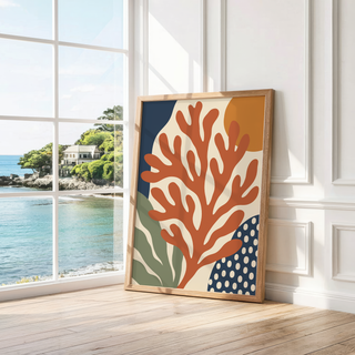 Rust red branching coral print leaning by a bright window with a sea view