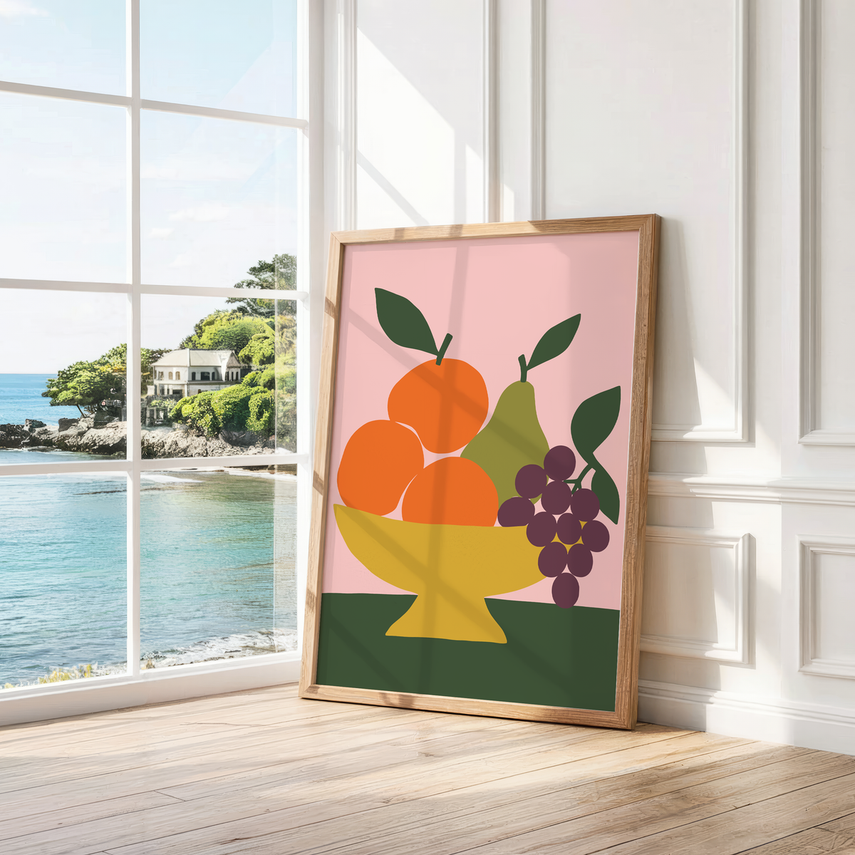 Mustard bowl of fruit on pink leaning by a bright window with a sea view