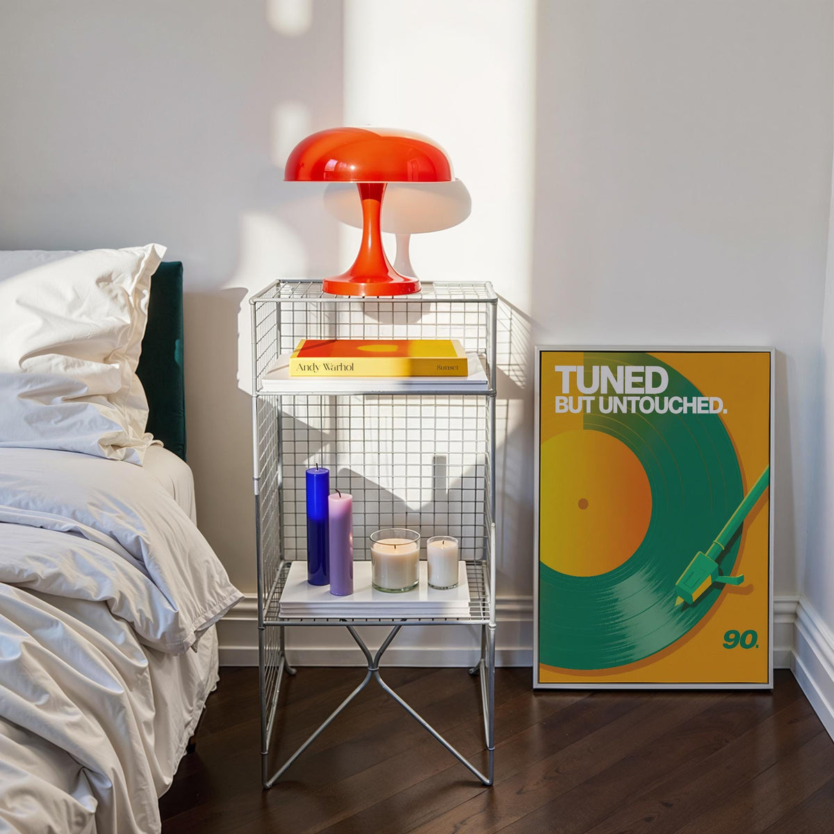 Vinyl Record Art Print leaning against a bedroom wall next to a wire side table with candles and a red lamp