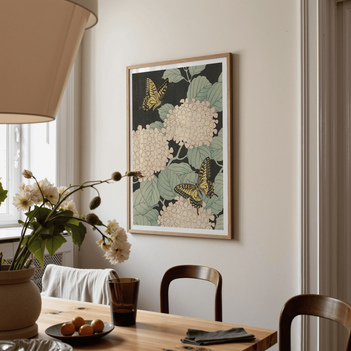 Butterfly Art Print hanging on a wall in a dining room with pale pink flowers and yellow butterflies