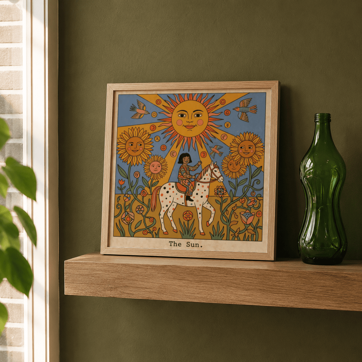 The Sun Tarot Card Art framed print on a wooden shelf with a green bottle beside it