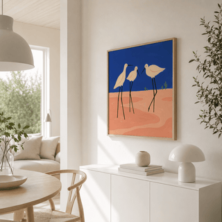 Print on a wall of minimalist birds with blue and peach hues above a white sideboard